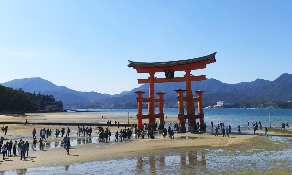 干潮のとき、宮島の鳥居の下に人が集まっている